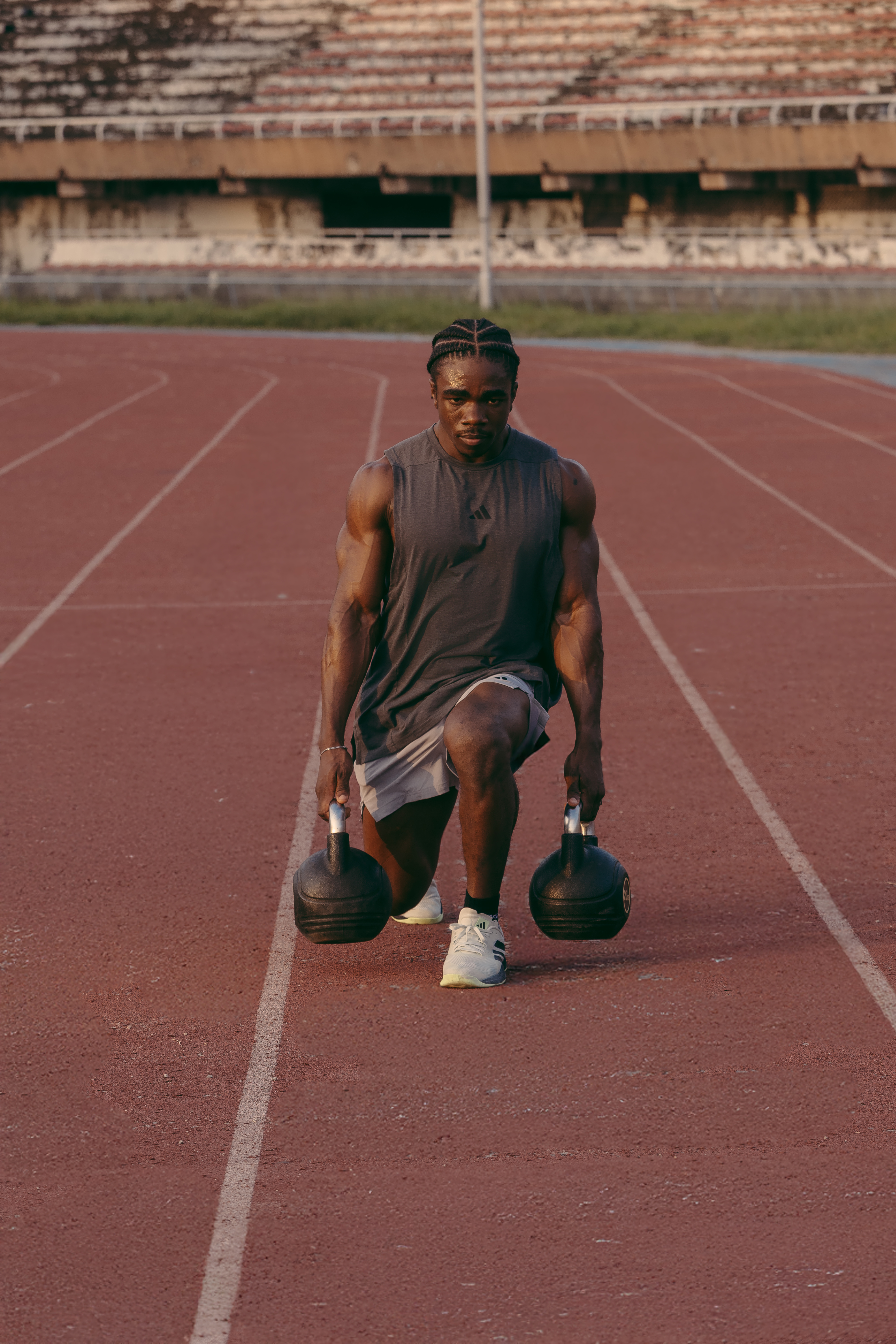 VV Fitness trainer Victor Magnus performing a kettlebell lunge on a track